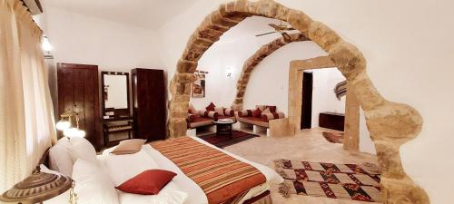 瓦迪穆萨Hayat Zaman Hotel And Resort Petra的一间带一张床铺的卧室,位于一个拱形的房间