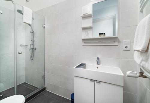布达佩斯RES City Residence Hotel Budapest的白色的浴室设有水槽和淋浴。