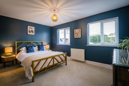 温德米尔Rockside - Luxury 1 bedroom home with hot tub central, parking pet friendly hot tub turns off 930pm的一间卧室拥有蓝色的墙壁,配有一张带蓝色枕头的床。