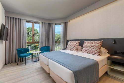 丰沙尔Enotel Magnólia的酒店客房设有一张床和一个阳台。
