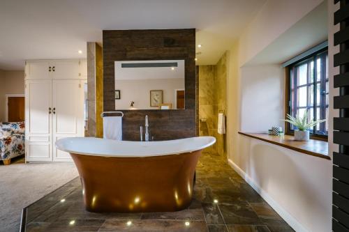 鲍内斯温德米尔Luxury 1 bed Villa - great location - Peaceful-Hot Tub的带浴缸和镜子的大浴室