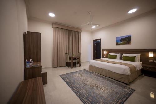 塞拉莱Anisa Residential Complex的一间卧室配有一张大床和一张桌子