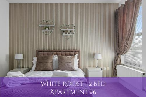 格雷夫森德The Roost Group - Bedford House Apartments的卧室配有带紫色床单的白色深色床