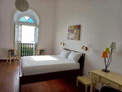 圣菲利佩Hotel Savana的一间卧室配有一张床、一张桌子和一个窗户。