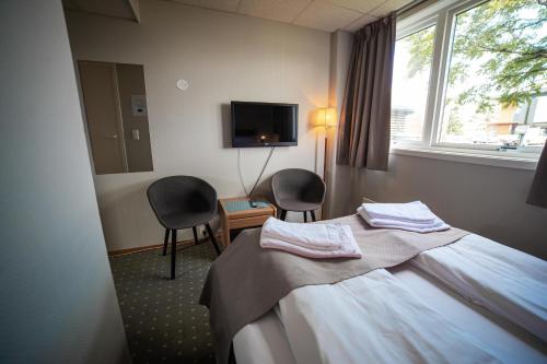 桑讷菲尤尔Torp Hotel的酒店客房配有1张床、2把椅子和电视。