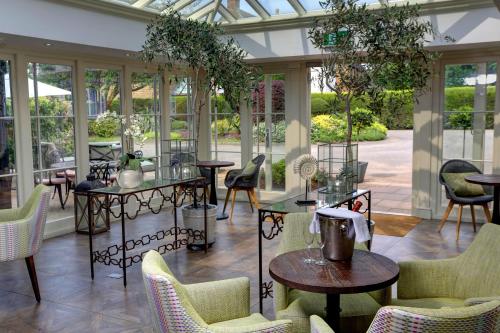班伯里Banbury Wroxton House Hotel的温室配有桌椅和窗户。