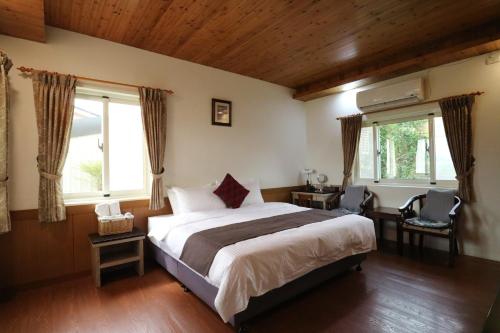瑞穗乡归园田居的一间卧室设有一张大床和两个窗户。
