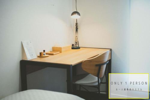 京都RAK KIYOMIZU - 1人旅専用hostel的一张桌子,放在一个房间里,上面有灯