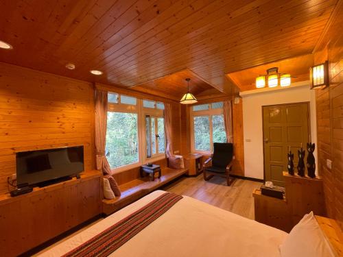 Hualing福缘山庄的一间卧室配有一张床和一台平面电视