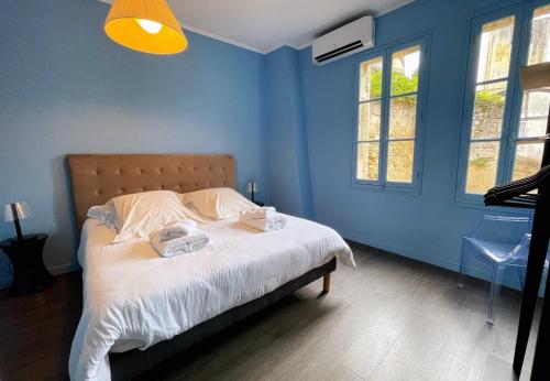 圣艾米隆La Petite Fontaine的蓝色卧室,配有带2条毛巾的床