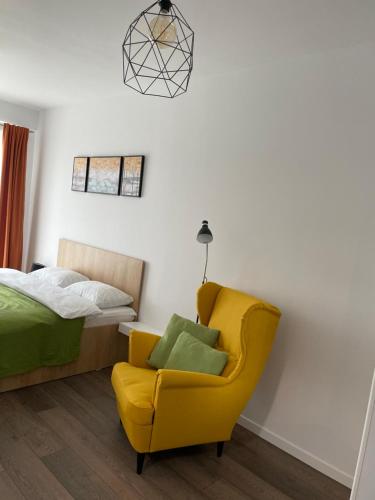 巴亚马雷Apartcentral的一间卧室配有黄色椅子和一张床