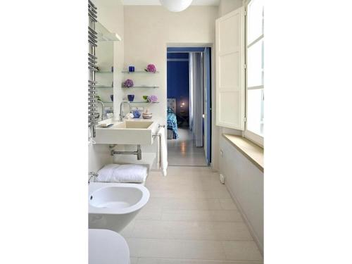 毕博纳的码头Beach Front Bibbona的白色的浴室设有水槽和卫生间。