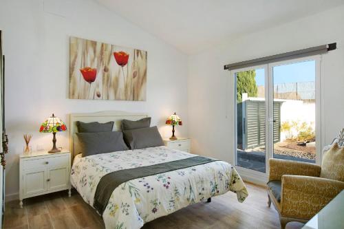 因赫尼奥Los Cipreses的卧室配有床、椅子和窗户。