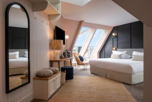 卡纳克Le Celtique & Spa的酒店客房,设有两张床和镜子