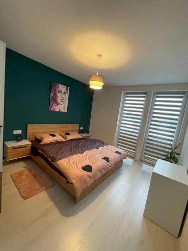 特尔古穆列什Apartament Bella的一间卧室设有一张床和绿色的墙壁