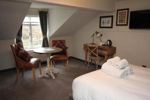 伍尔乡下人旅馆的酒店客房配有一张床铺、一张桌子和一张书桌。