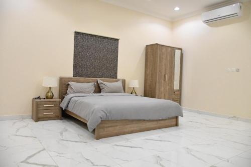 达曼SHALLY VILLAGE的一间设有一张大床和大理石地板的卧室
