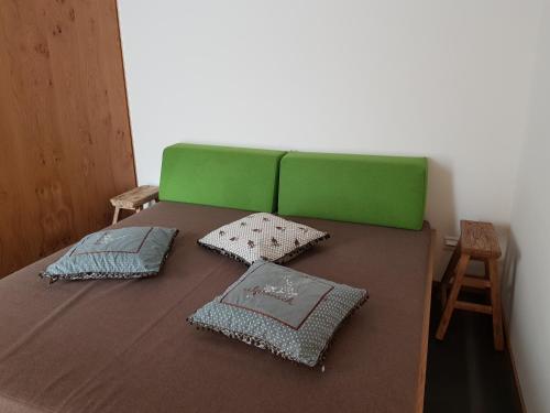 帕尔潘Domofaber 296 Gu的一张绿色的床,上面有三个枕头