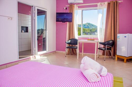 贝岛Cambria Hotel的一间卧室设有紫色墙壁和一张带毛巾的床