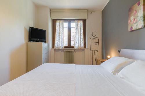 维罗纳Le Volpi in città的卧室配有白色的床和窗户。