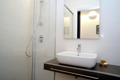 圣塞瓦斯蒂安罗尔迪亚旅馆的白色的浴室设有水槽和淋浴。