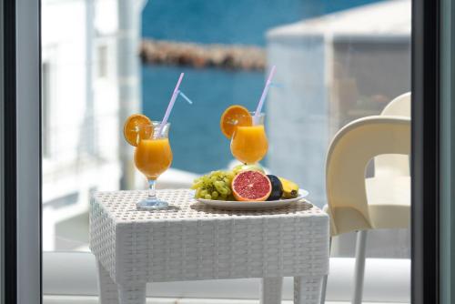 依拉佩特拉Coral Hotel的一张桌子,上面放有一盘水果和两杯橙汁