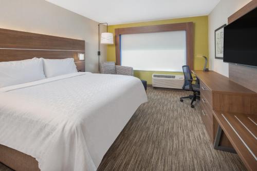 奇科Holiday Inn Express & Suites - Chico, an IHG Hotel的配有一张床和一台平面电视的酒店客房
