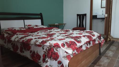 伊塔尼亚恩Cantinho do Nick的一间卧室配有一张带红白毯子的床