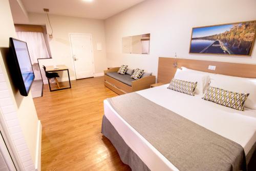博尼图Promenade Bonito All Suites的一间卧室配有一张大床和一张沙发