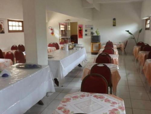 巴拉那州蓬塔尔Hotel Morada de Leste的一间带桌椅的餐厅以及一间带桌椅的房间