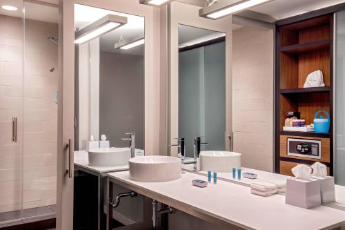 阿尔法利塔Aloft Alpharetta的一间带两个盥洗盆和大镜子的浴室