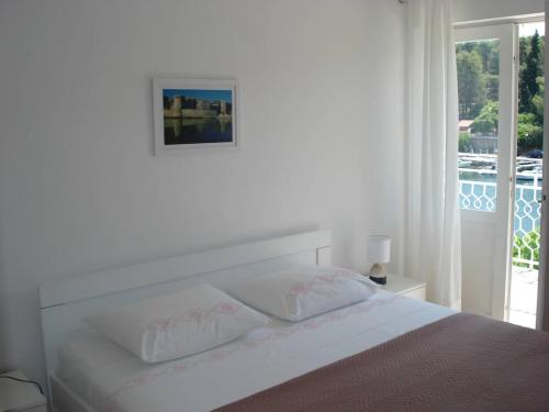 科尔丘拉卢卡公寓的白色的卧室设有白色的床和窗户。