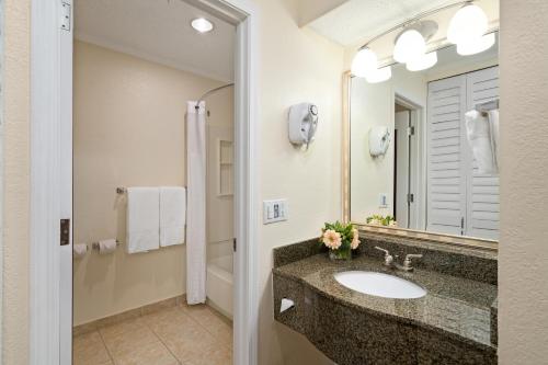 拿骚天堂岛康福特茵套房酒店的一间带水槽和镜子的浴室