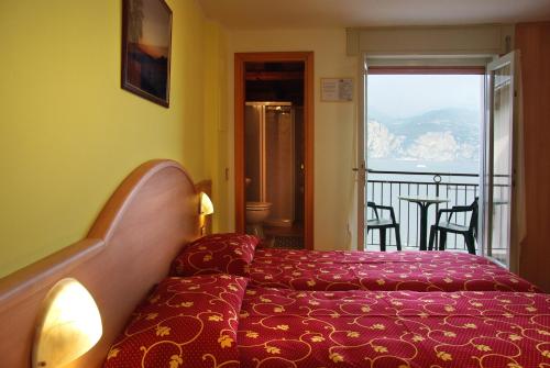 布雷佐内加尔达Hotel Residence Panoramica的酒店客房设有一张床和一个阳台。