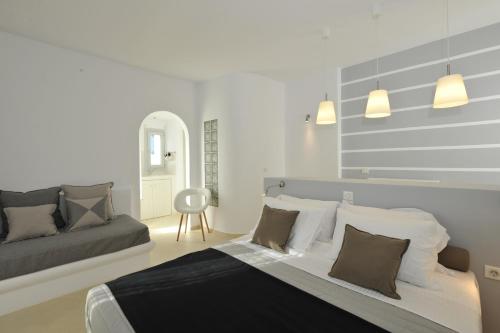 纳乌萨浪漫套房公寓式酒店的一间卧室配有一张大床和一张沙发