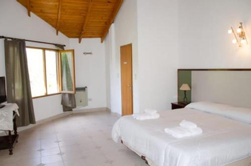 乔斯马拉尔Hosteria La Farfalla的一间卧室配有两张床和电视。