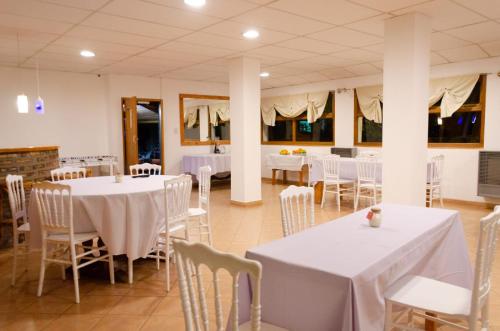 乔斯马拉尔Hosteria La Farfalla的一间设有白色桌椅的用餐室