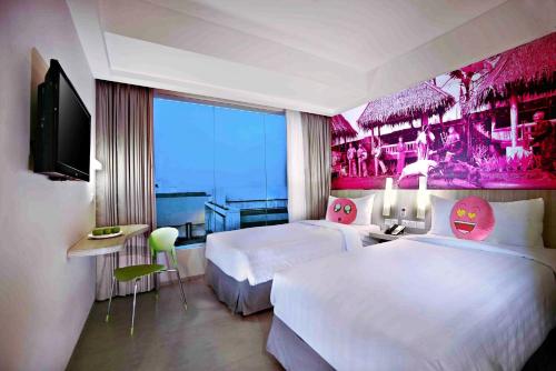 加鲁特希曼努克贾璐酒店的一间酒店客房,设有两张床和电视