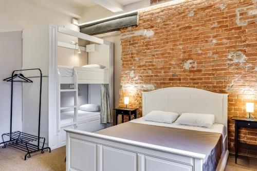顿河畔罗斯托夫纳博科夫阁楼酒店的一间卧室设有一张床和砖墙