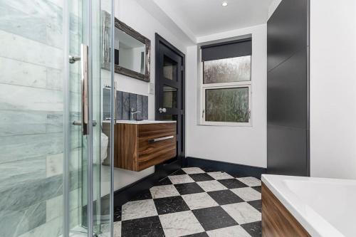 韦克菲尔德BOOTique House - Luxury Group Accommodation in Wakefield的一间带玻璃淋浴间和 ⁇ 格地板的浴室