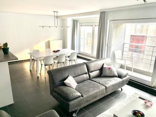 奥斯坦德Vakantieappartement Emiel Centrum Oostende met garage的客厅配有沙发和桌子