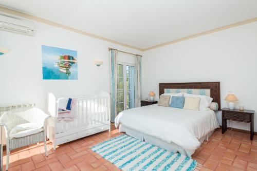 拉戈阿Peaceful 4BR villa on Gramacho golf resort w/ private pool的白色卧室配有床和椅子