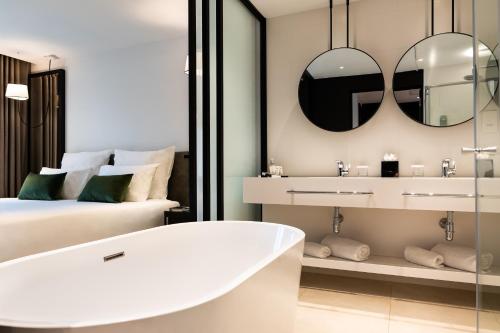圣朱利安斯瓦伦蒂娜酒店的带浴缸的浴室和1间带1张床的卧室