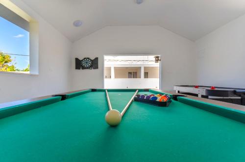 特罗吉尔Apartments and Rooms Villa Niko的台球室,带台球桌和球