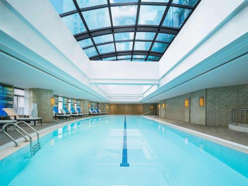 上海上海宏安瑞士大酒店的一个带玻璃天花板的大型游泳池