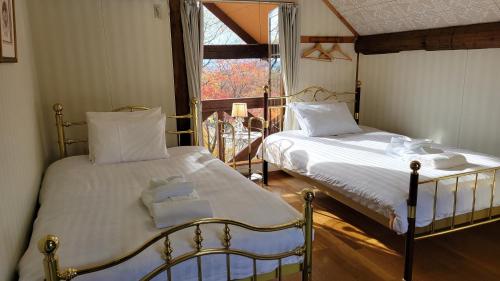 Takanoフォレスト倶楽部　田園的一间卧室设有两张床和窗户。