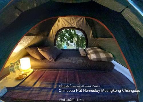 Mueang KhongChinopuu Hut Homestay Muangkong ชิโนปู ฮัท โฮมสเตย์ เมืองคอง เชียงดาว的帐篷的海报,帐篷内有一张床