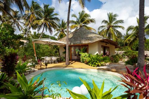 帕杰桑希巴白沙豪华别墅Spa度假村 - 罗莱夏朵精品酒店的一座别墅,设有游泳池和棕榈树
