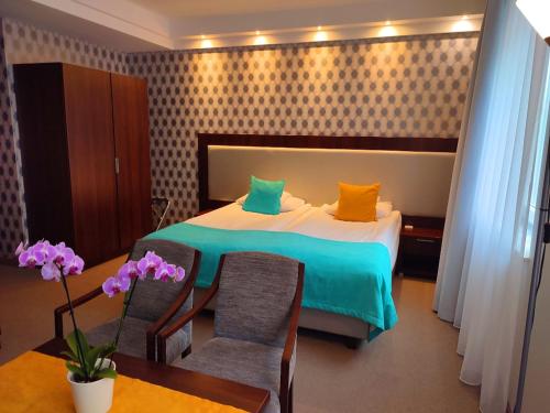 什切青城堡中心酒店的卧室配有一张床和一张桌子及椅子