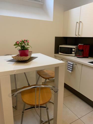 美因茨奥斯坦霍夫度假公寓的厨房配有桌子、两把椅子和微波炉
